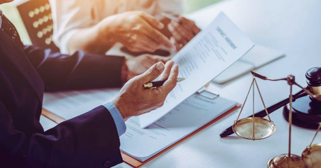 Abogado mercantil revisando un contrato comercial y asesorando a un cliente sobre el cumplimiento de relaciones empresariales en México